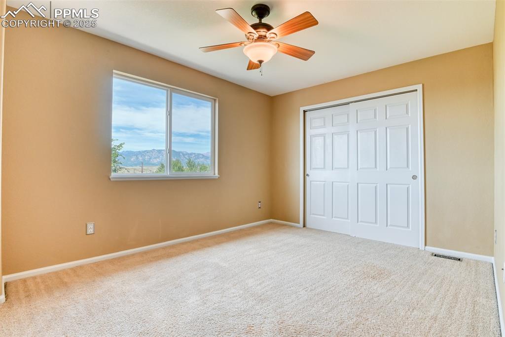 Image 31 of 49: Unfurnished bedroom with carpet floors, ceiling fan, a mountain view, and a