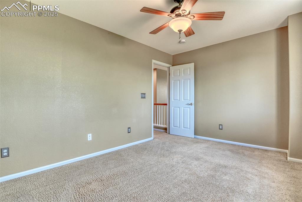 Image 32 of 49: Spare room with carpet and a ceiling fan