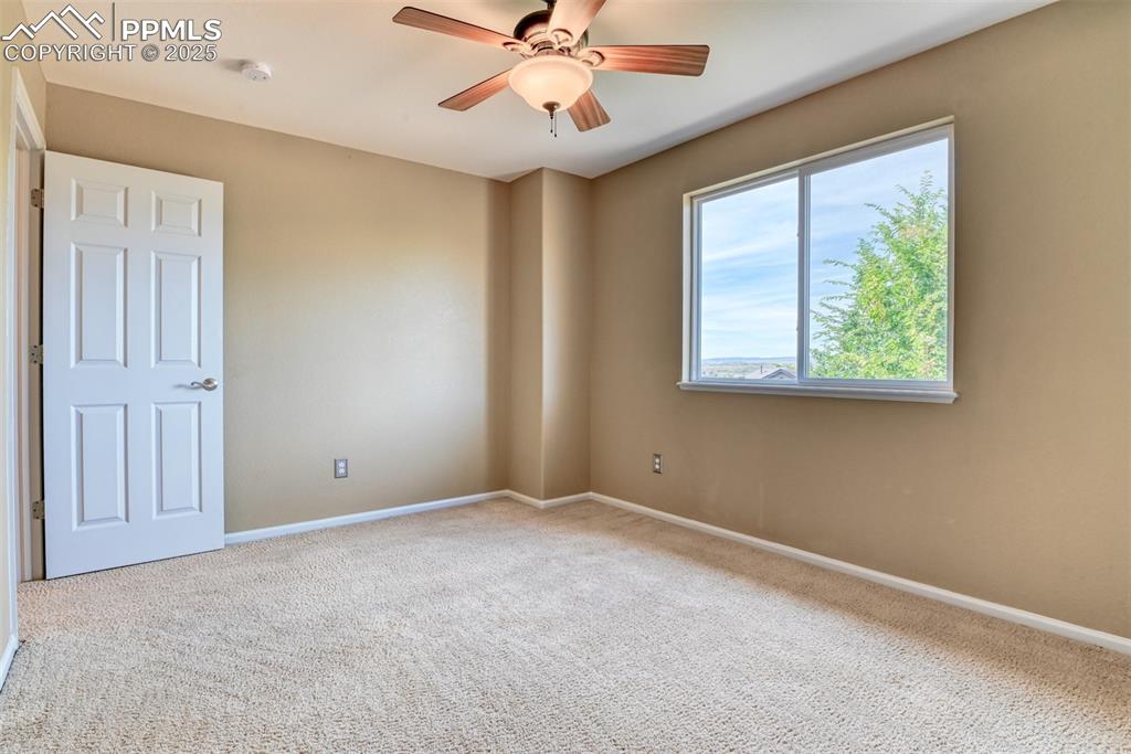 Image 33 of 49: Carpeted empty room featuring baseboards and a ceiling fan