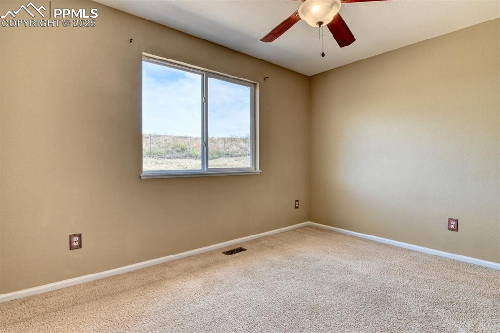Image 34 of 49: Empty room featuring carpet floors and a ceiling fan
