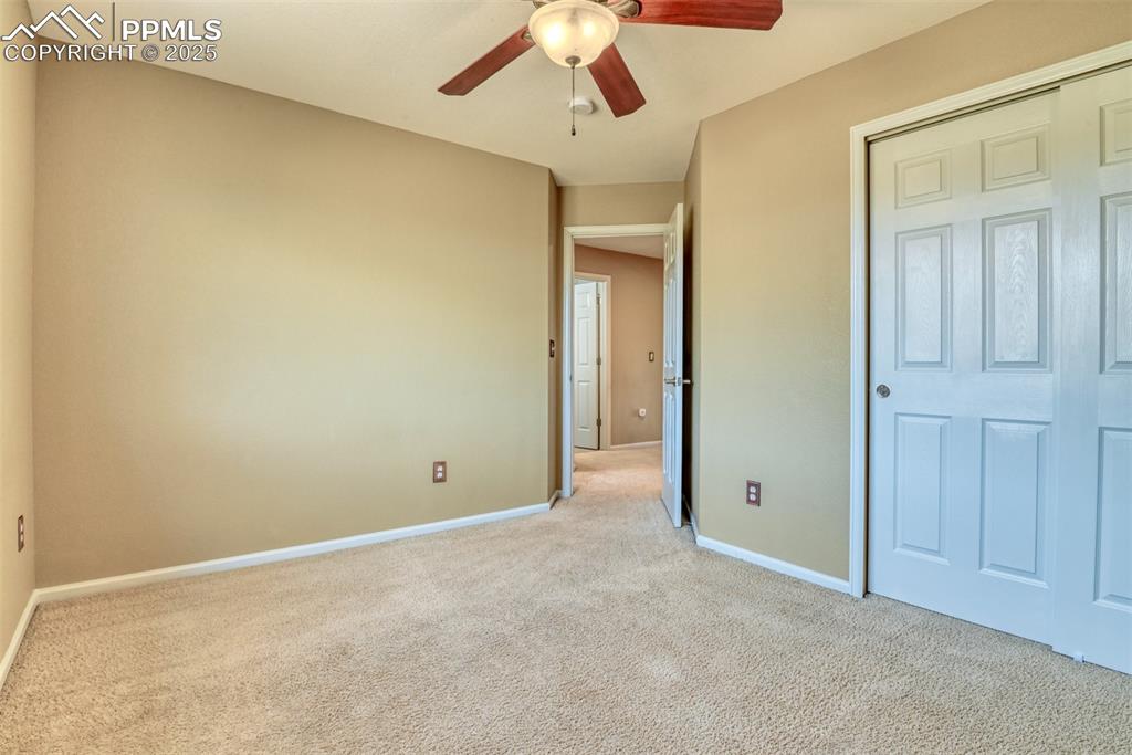 Image 35 of 49: Unfurnished bedroom with carpet flooring, a ceiling fan, and a closet