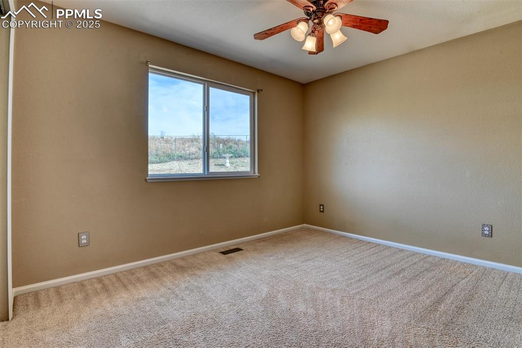 Image 38 of 49: Carpeted spare room featuring baseboards and a ceiling fan