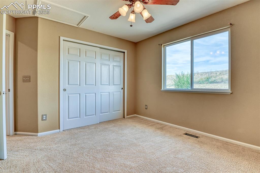 Image 39 of 49: Unfurnished bedroom featuring attic access, carpet flooring, a closet, and