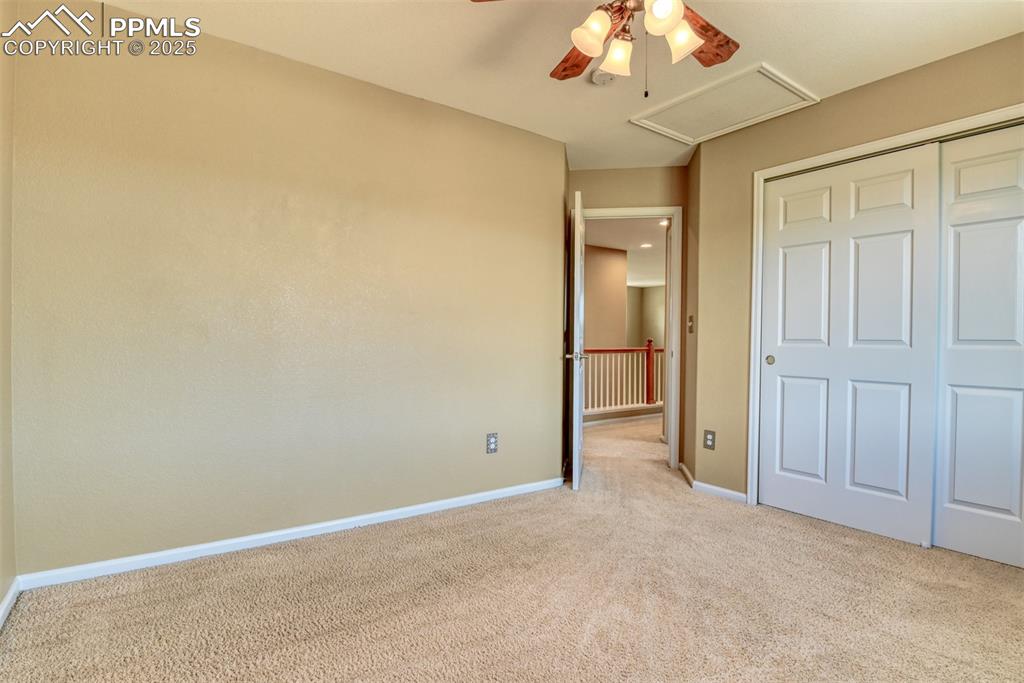 Image 40 of 49: Unfurnished bedroom featuring carpet floors, a closet, attic access, and a