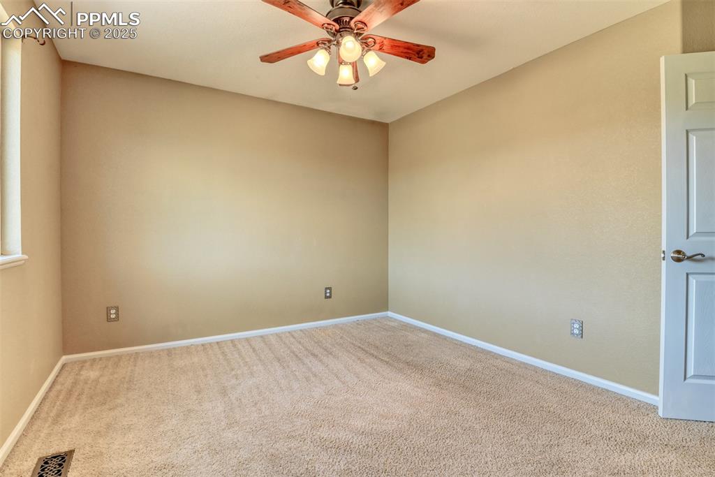 Image 41 of 49: Empty room with carpet flooring and ceiling fan