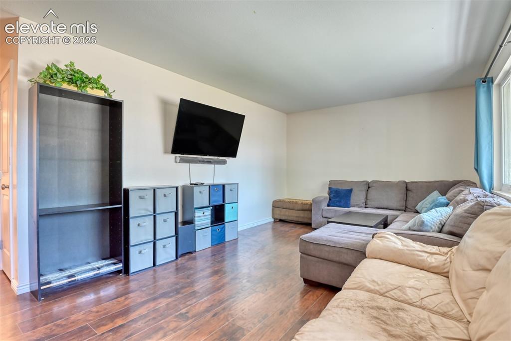 Image 8 of 32: Wood-finish flooring throughout, with a wall-mounted television