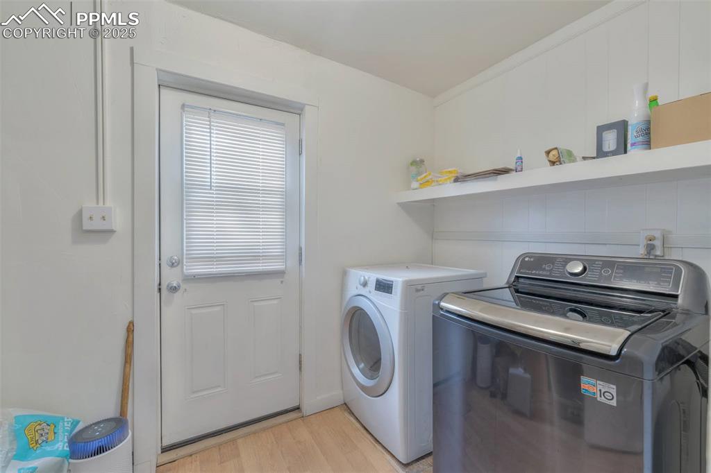 Image 23 of 38: The laundry room has room for storage and door to the alley side of the hom