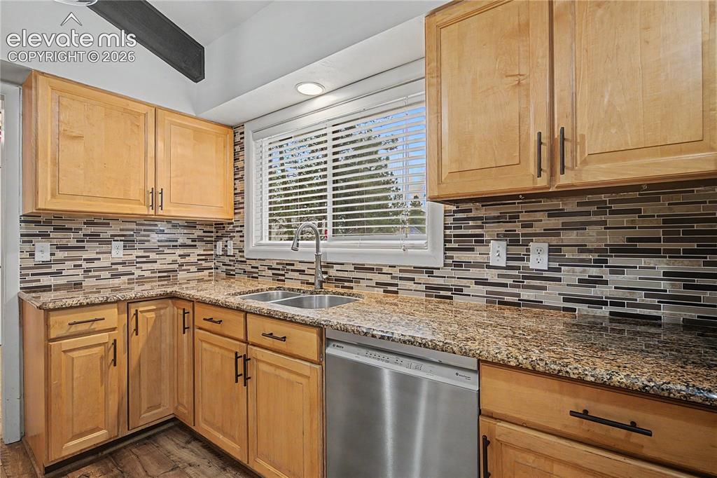 Image 10 of 46: Kitchen featuring blonde wood cabinetry, granite countertops, a mosaic tile