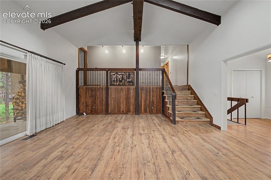Image 12 of 46: Vaulted ceilings featuring exposed wood beams enhance this open interior
