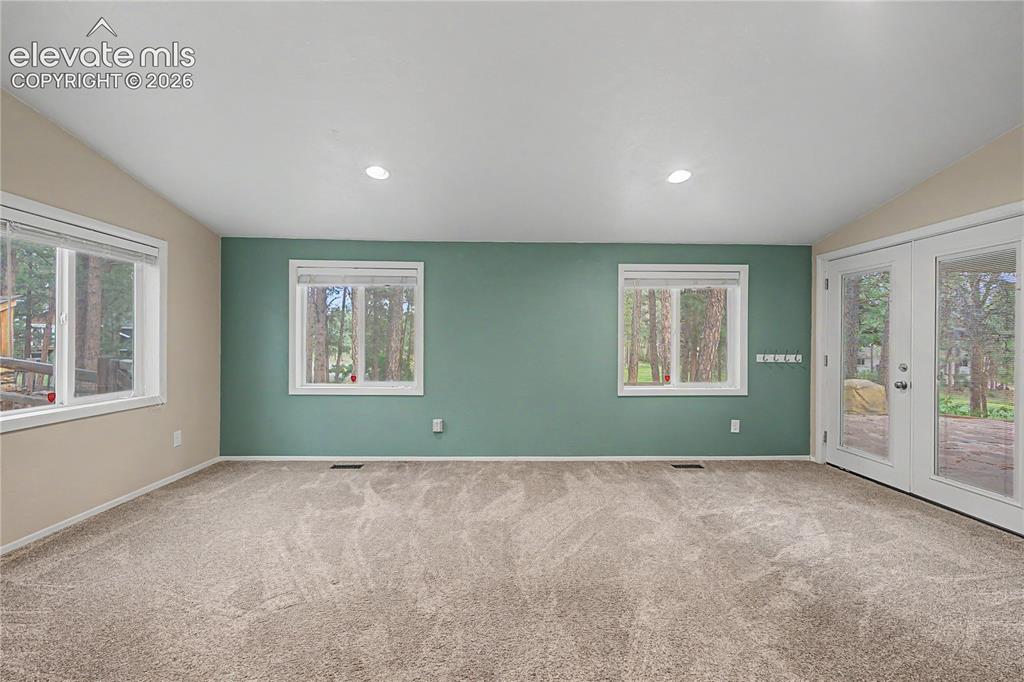 Image 17 of 46: Spacious room featuring neutral carpeting and recessed lighting