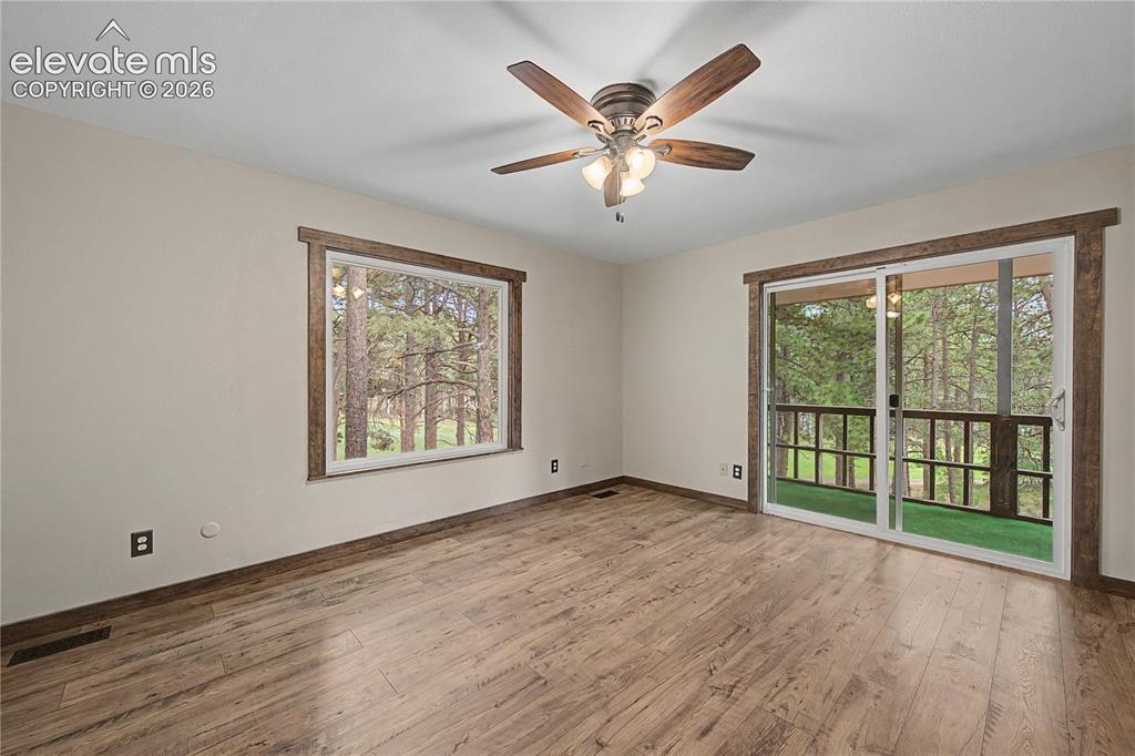 Image 22 of 46: Interior room featuring wood-finish flooring, a large picture window, and g