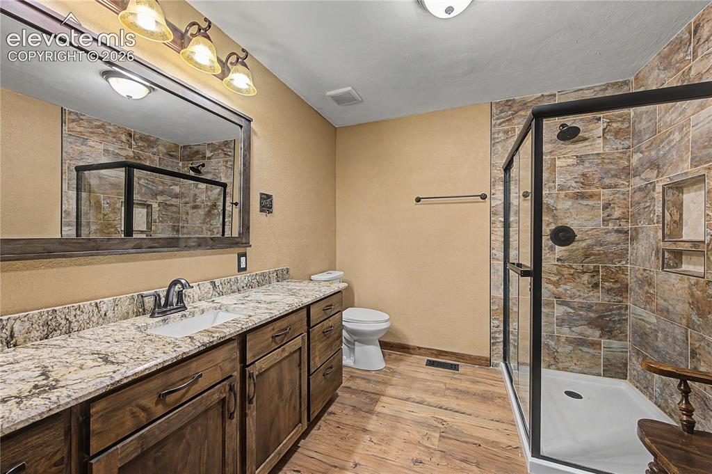 Image 24 of 46: Bathroom featuring a glass-enclosed shower with tile surround, a spacious v