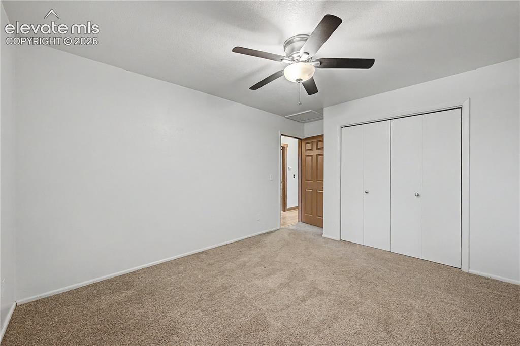 Image 27 of 46: Carpeted room with a ceiling fan light fixture