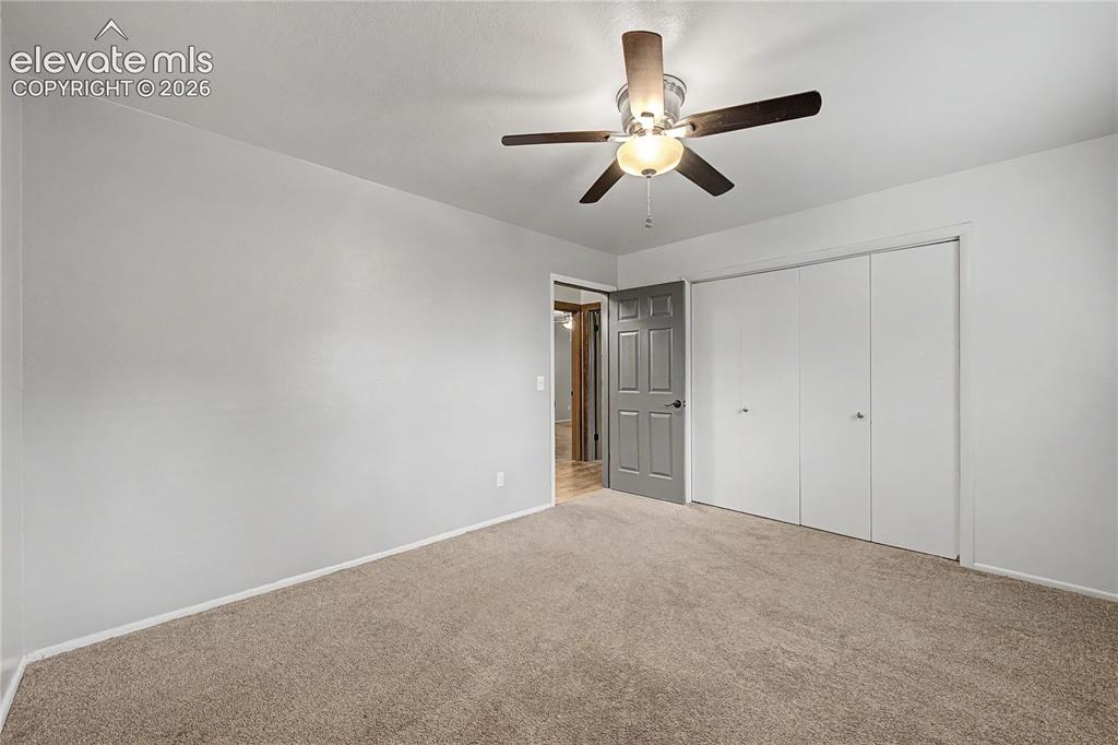 Image 31 of 46: Carpeted room featuring light gray walls, a ceiling fan with light fixture,