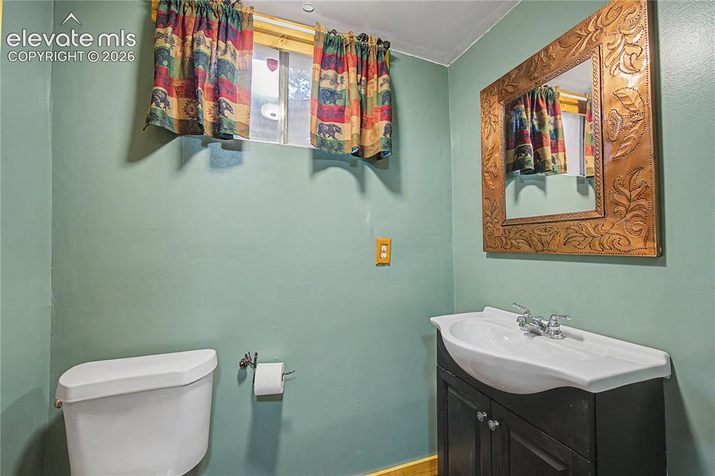 Image 36 of 46: Bathroom featuring a vanity with a white basin and dark wood-finish cabinet