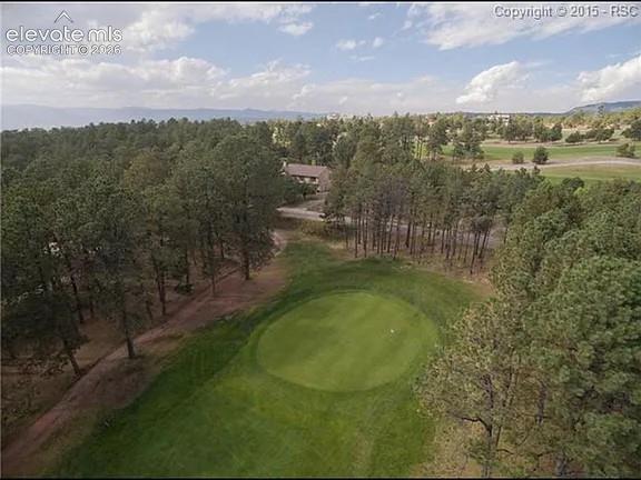 Image 4 of 46: Expansive green golf course with a central putting green