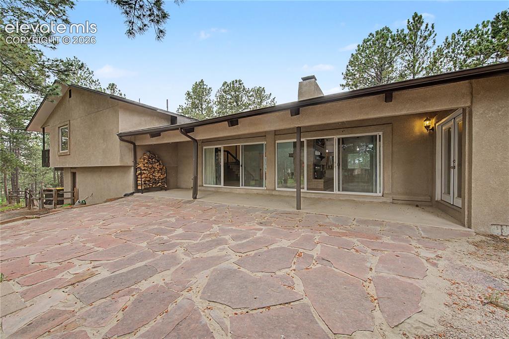 Image 41 of 46: Expansive flagstone patio with a covered outdoor area, stucco exterior, mul