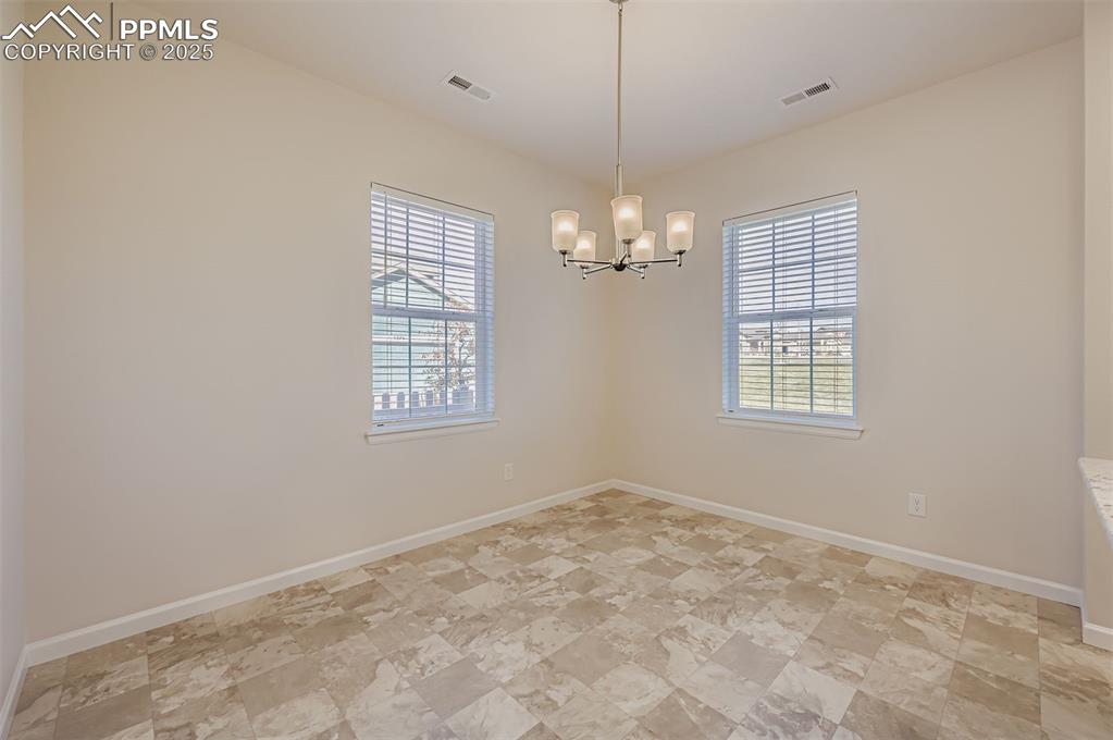 Image 12 of 30: Spare room featuring plenty of natural light and a chandelier