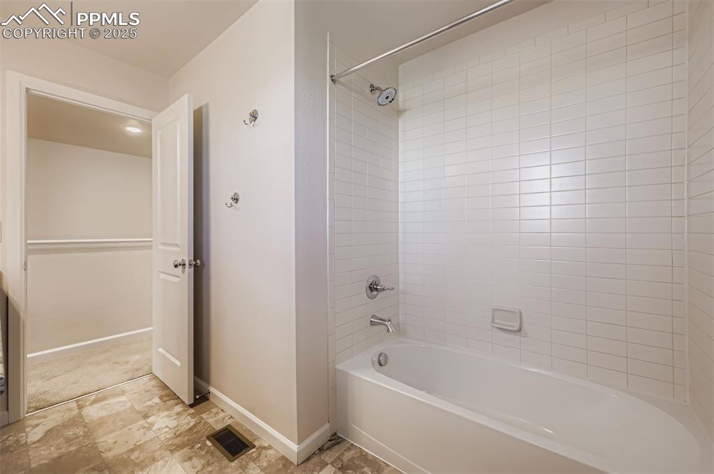 Image 24 of 30: Bathroom featuring bathing tub / shower combination and baseboards