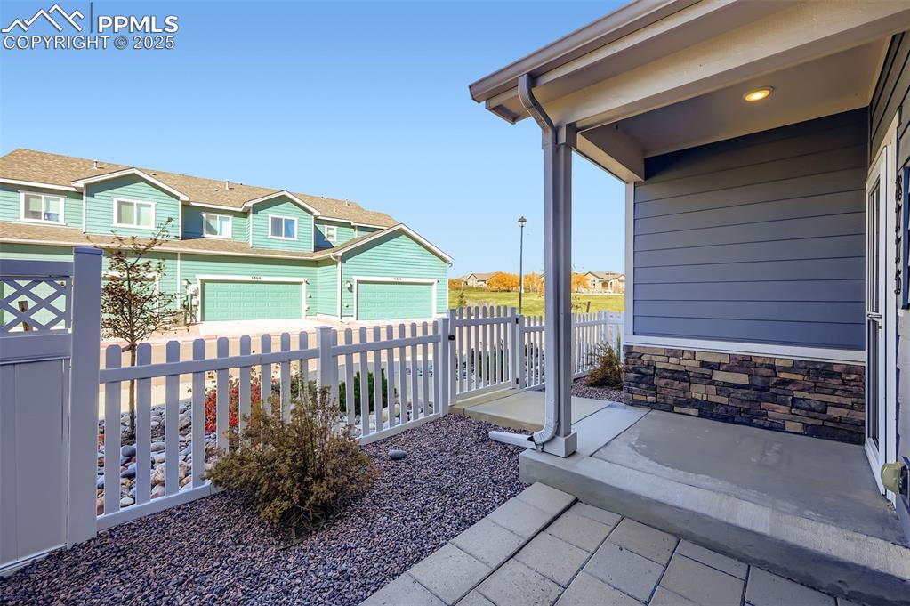 Image 26 of 30: Covered porch featuring a residential view and a garage