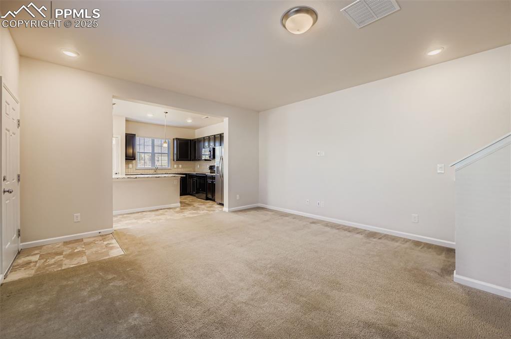 Image 6 of 30: Unfurnished living room with light carpet and recessed lighting