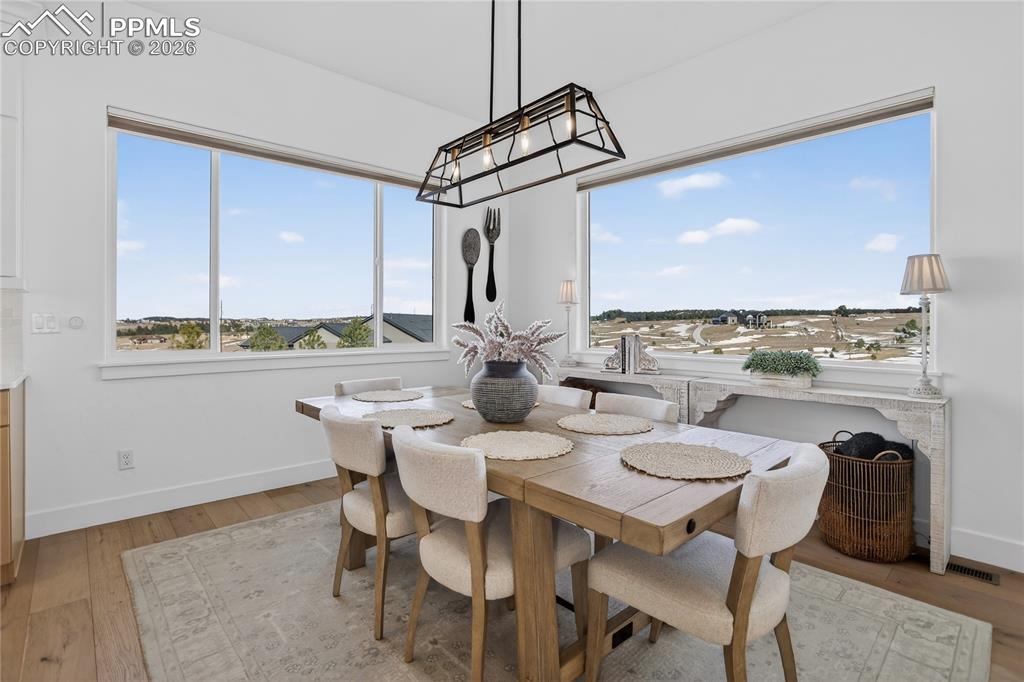 Image 14 of 49: Eat-in kitchen area with designer lighting, automated window shades