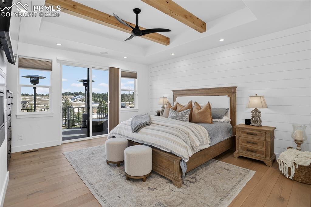 Image 18 of 49: Main floor Primary BR with shiplap walls and knotty alder wood beams