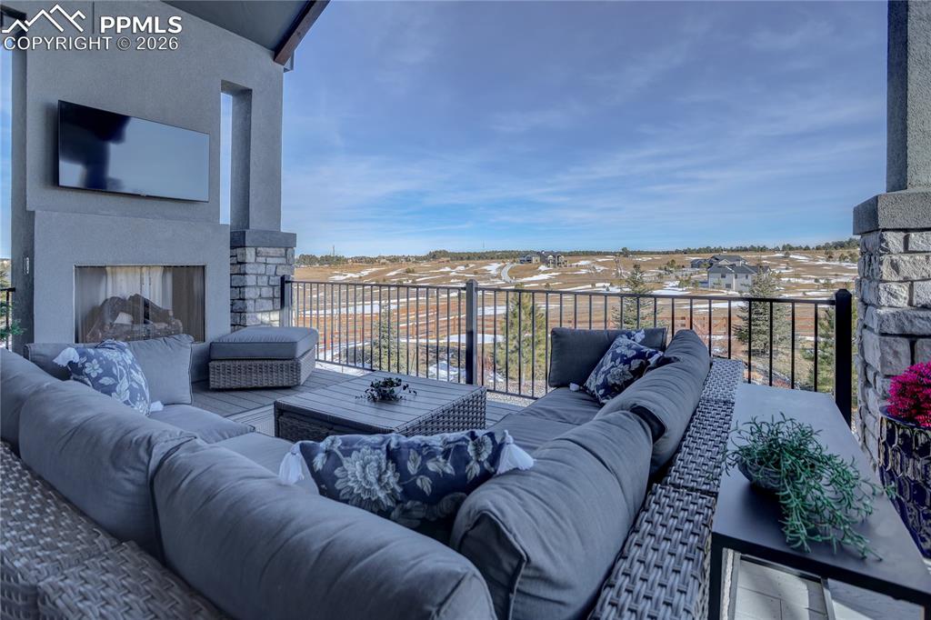 Image 40 of 49: Main-level covered composite deck with gas fireplace & TV