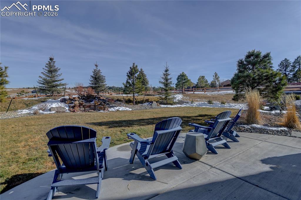 Image 45 of 49: Lower-level open patio area with view of stone water feature