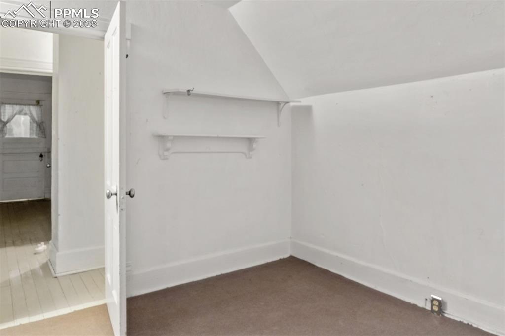 Image 18 of 24: Bonus room with vaulted ceiling and carpet floors