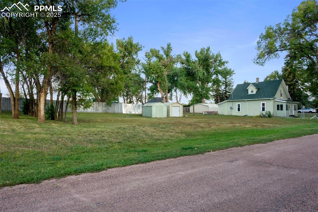 Image 2 of 24: View of yard featuring a shed and a detached garage