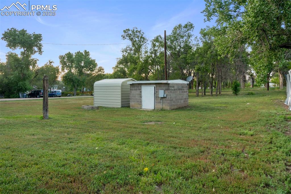 Image 22 of 24: View of grassy yard with an outdoor structure