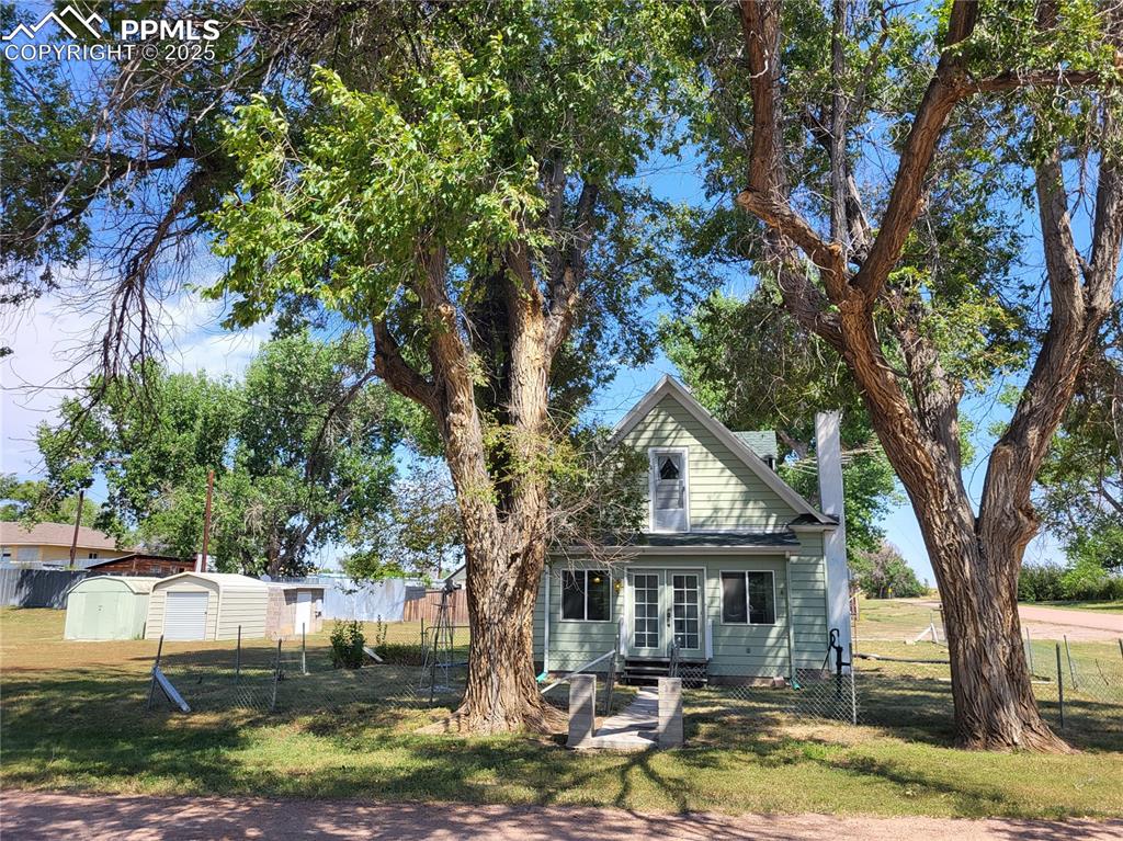 Image 24 of 24: Rear view of property with a fenced backyard and an outdoor structure