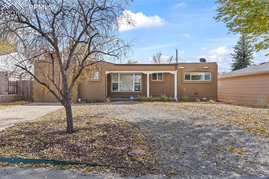 Caption: View of front of house featuring stucco siding and driveway