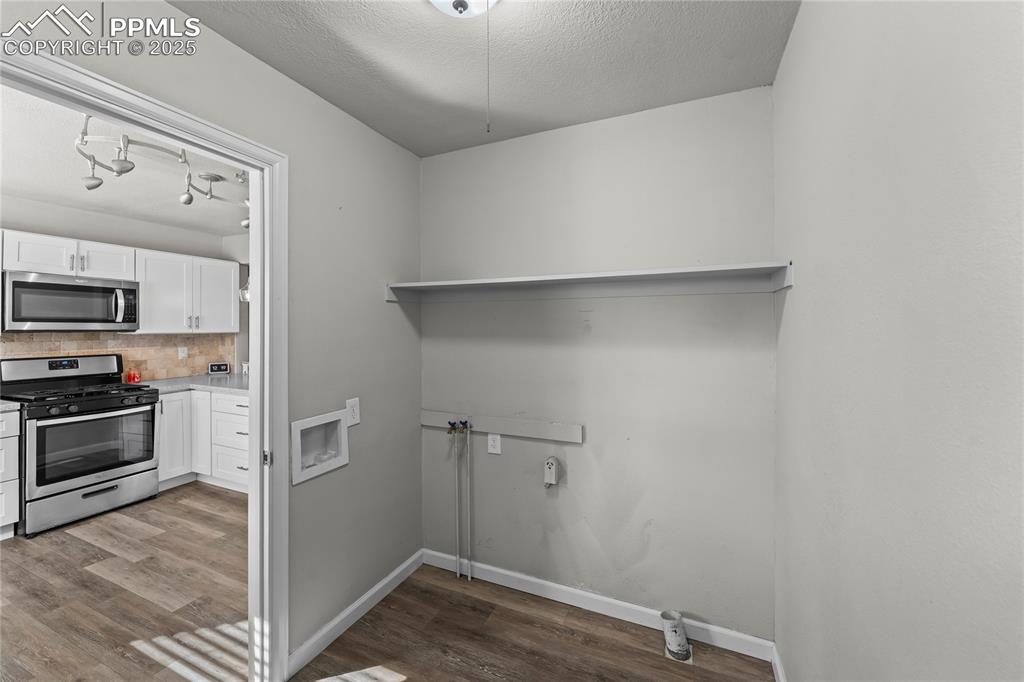 Image 11 of 24: Laundry room with hookup for a washing machine, light wood-style flooring,