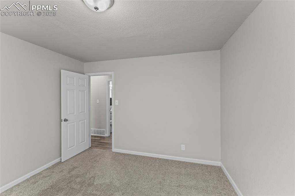 Image 14 of 24: Carpeted spare room featuring baseboards and a textured ceiling