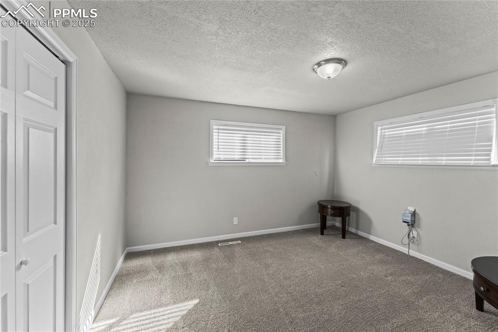 Image 16 of 24: Carpeted spare room featuring a textured ceiling and baseboards