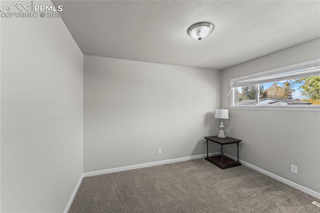 Image 18 of 24: Carpeted empty room with baseboards and a textured ceiling
