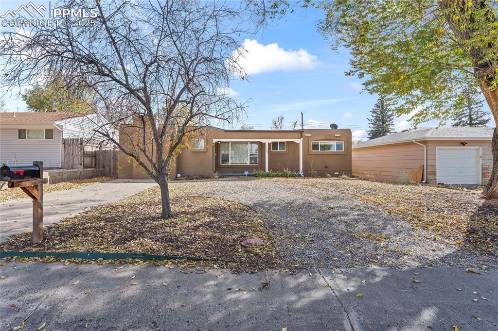 Image 22 of 24: Ranch-style house with stucco siding and concrete driveway