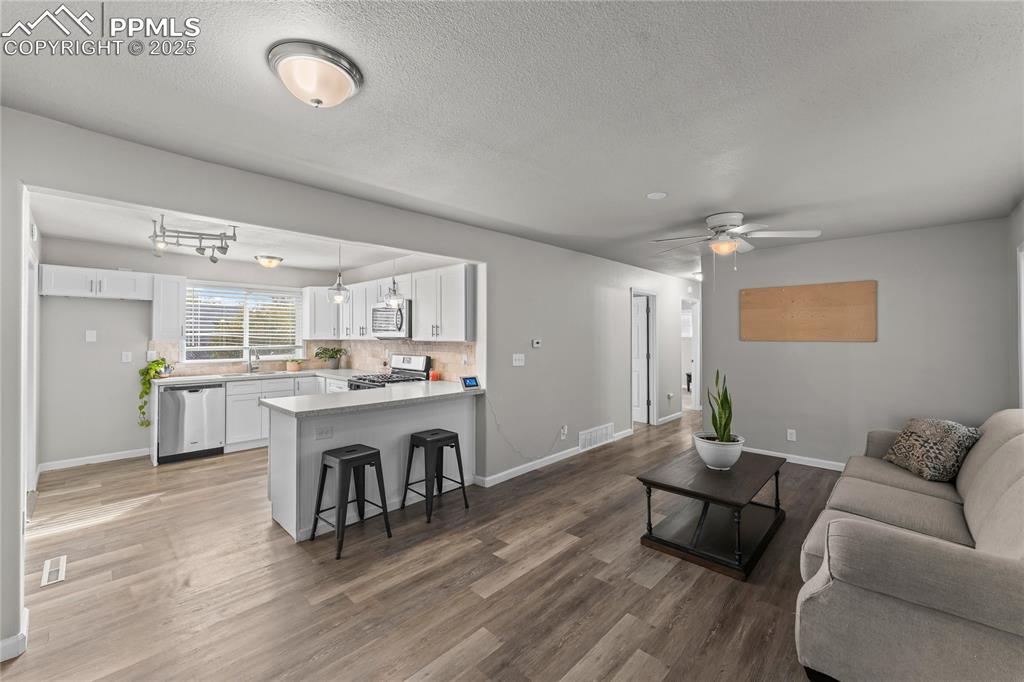 Image 3 of 24: Living room featuring a textured ceiling, light wood-style flooring, and ce