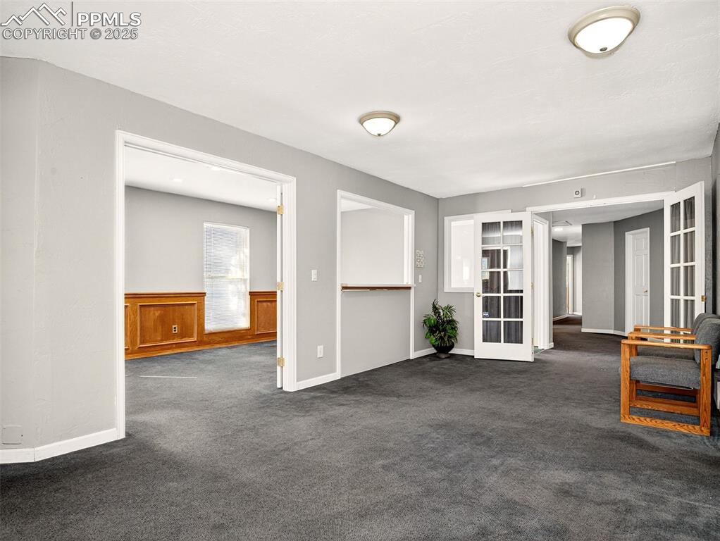 Image 7 of 17: Spare room with dark carpet and french doors