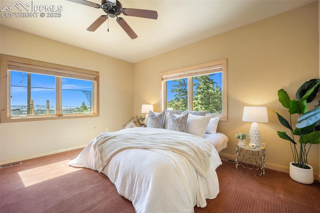 Image 17 of 50: Carpeted bedroom with baseboards and ceiling fan