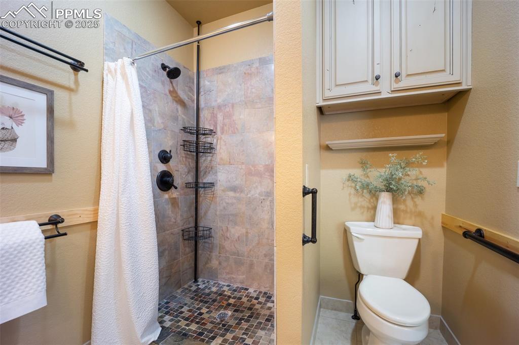 Image 20 of 50: Full bath with a tile shower and toilet