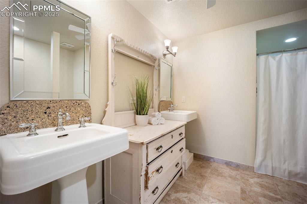 Image 30 of 50: Full bath featuring a sink and a shower with shower curtain