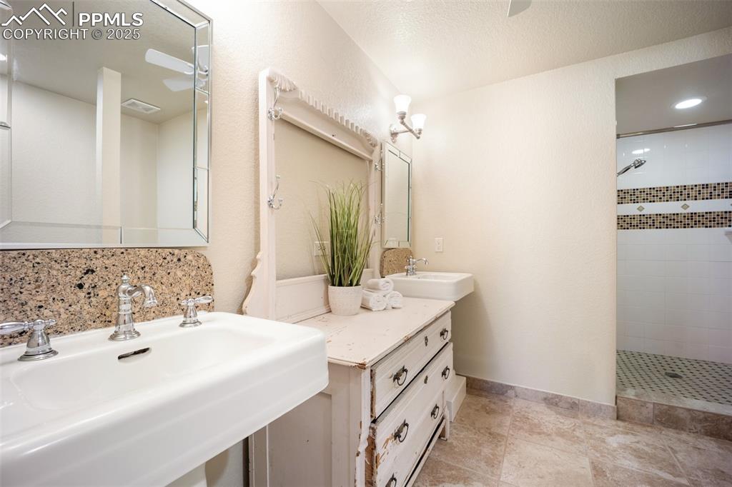 Image 31 of 50: Full bath with a tile shower, decorative backsplash, and recessed lighting