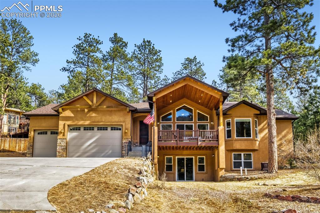 Image 1 of 47: View of front facade with a garage, driveway, stucco siding, and stone sidi