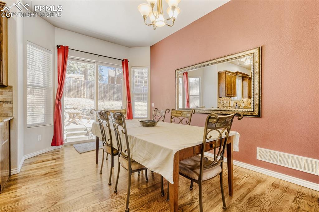 Image 15 of 47: Dining room featuring hardwood flooring and walks out to rear patio