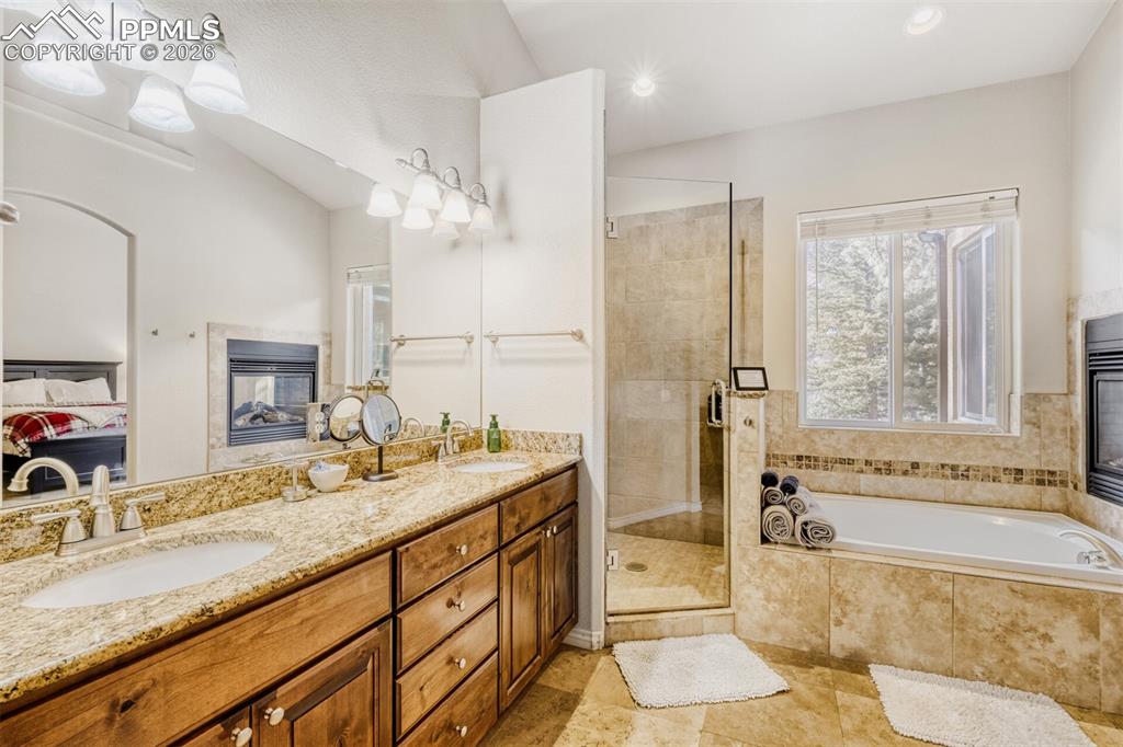 Image 20 of 47: Ensuite bathroom with double vanity, a garden tub, a stall shower, and rece