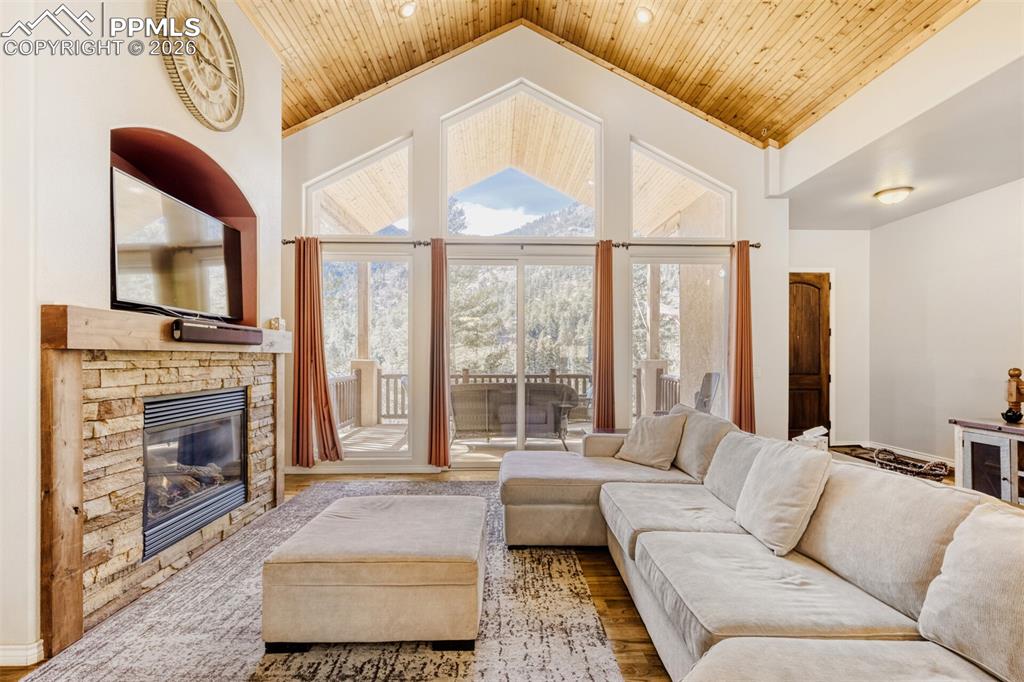 Image 8 of 47: Living area with soaring wooden ceiling, a fireplace, and wood floors- the 