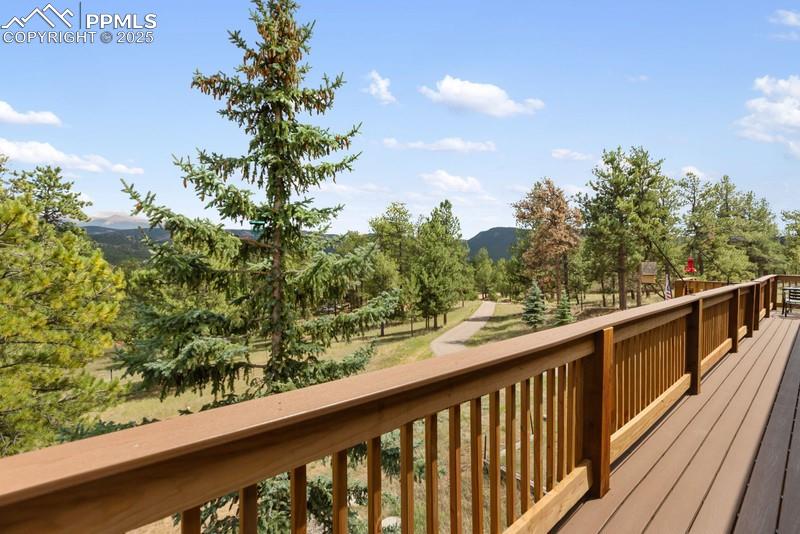 Image 11 of 37: Deck with view of wooded area and a mountain view